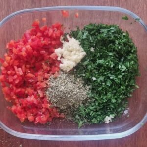 Chimichurri Vegano Receta: Todos los ingredientes en un bowl listos para ser mezclados con el aceite de oliva, el vinagre y la sal.