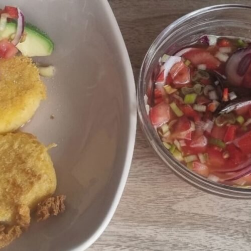 Agrio ecuatoriano con kombucha en un bowl al lado derecho de la foto. Al lado izquierdo un platillo con agrio ecuatoriano de acompañamiento.