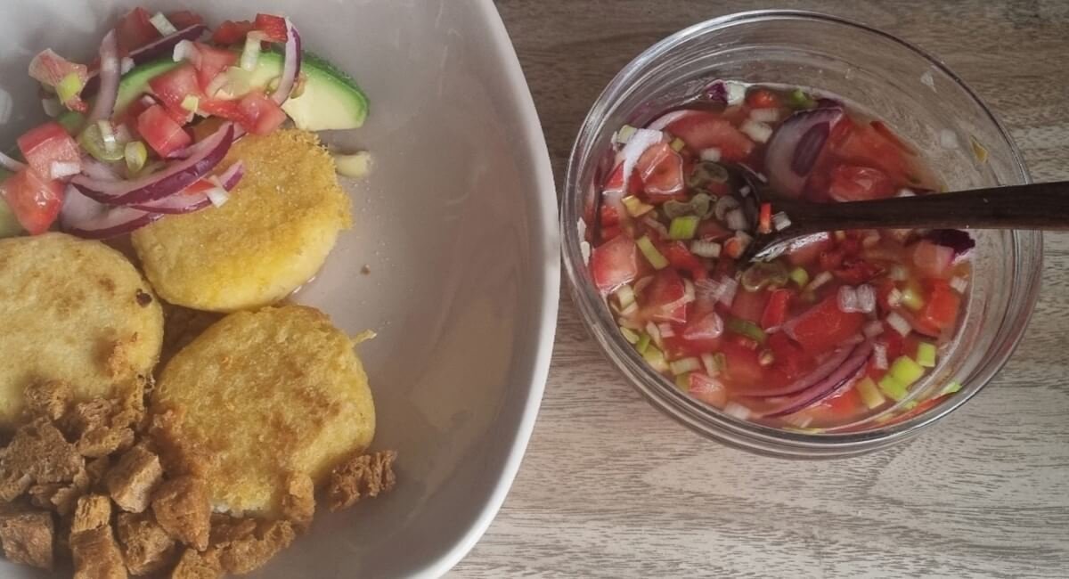 Agrio ecuatoriano con kombucha en un bowl al lado derecho de la foto. Al lado izquierdo un platillo con agrio ecuatoriano de acompañamiento.