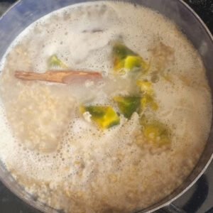 Receta de colada de avena o Quaker de naranjilla. Una olla con todos los ingredientes excepto la naranjilla y el endulzante hirviendo.