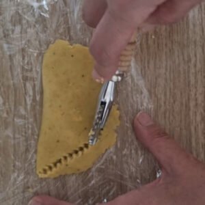 Paso número siete de la preparación de empanas veganas de plátano verde: Cortando los bordes de la empanada con un cortador de ravioli.
