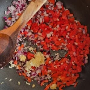 Receta de Seco de Chivo con Naranjilla vegano. Paso 4: Reservamos nuestra proteína y en ese mismo aceite haremos el refrito con la cebolla picada, el pimiento picado, y los ajos machacados.