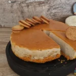 Cheesecake de dulce de leche con alfajores manabitas encima.