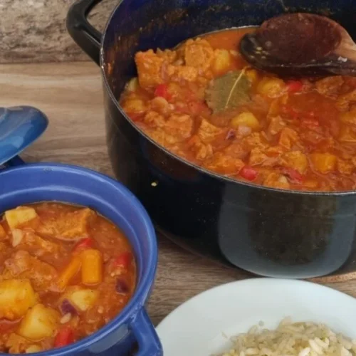 Goulash vegano versión vegana en dos ollas. Una de ellas es una olla de metal y la otra es una de cerámica azul.