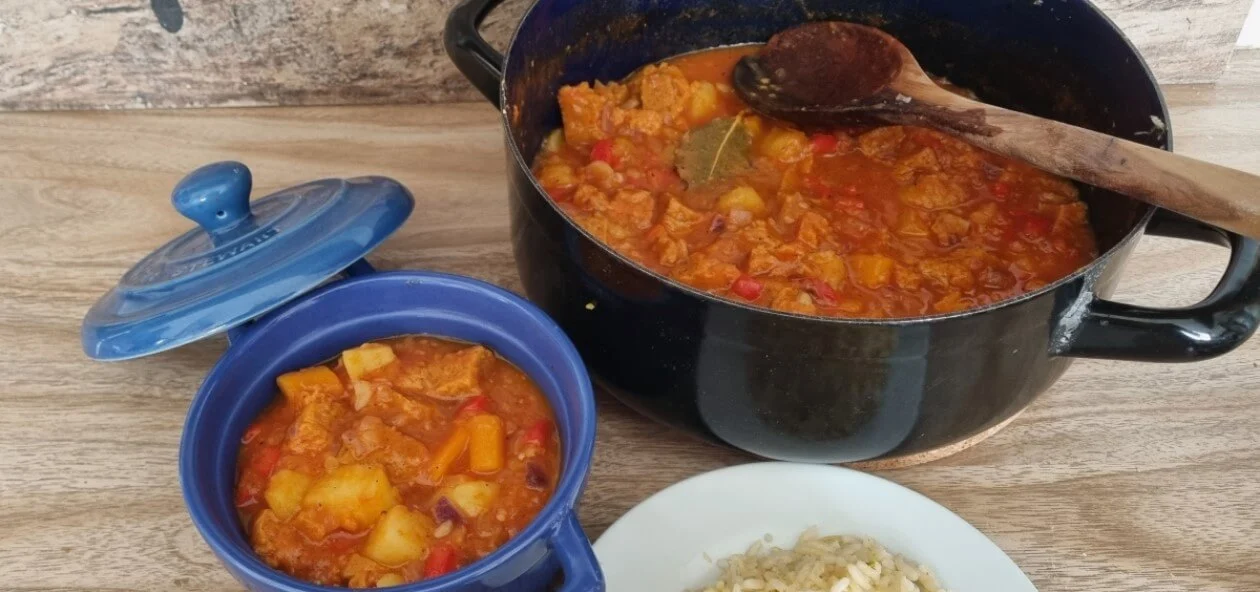 Goulash vegano versión vegana en dos ollas. Una de ellas es una olla de metal y la otra es una de cerámica azul.