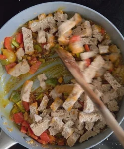 Migas pastoriles veganas de Extremadura - Receta tradicional - Añadir la mantequilla, el pimentón y el pan, revolviendo constantemente para evitar que se pegue.