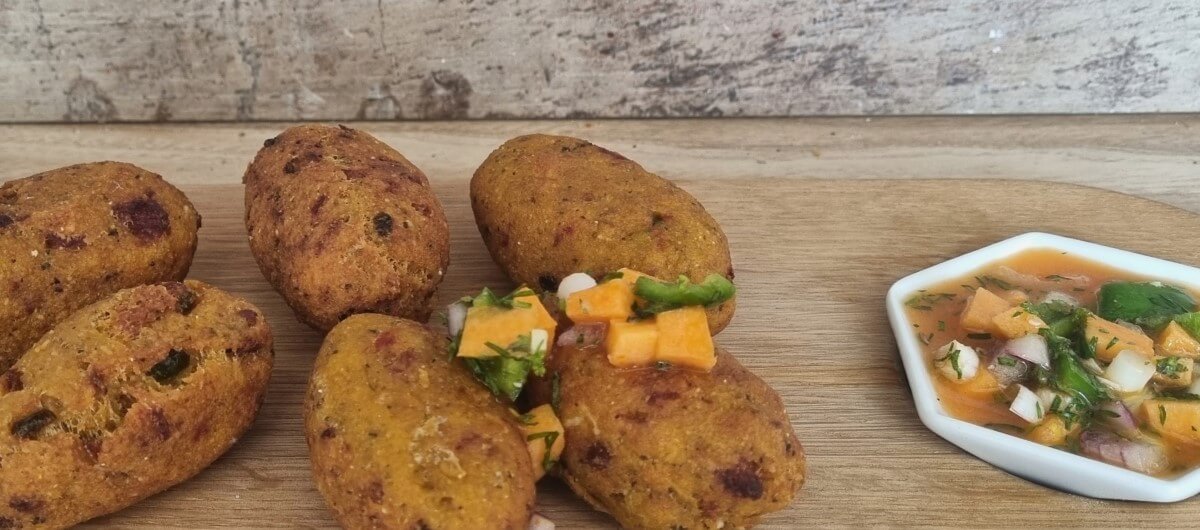 Receta de corviche ecuatoriano vegano: 6 corviches listos con su ají y un pequeño bowl de ají al lado derecho.